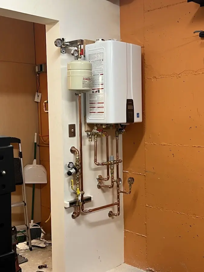 Plumbing technician inspecting water heater connections in Catalina